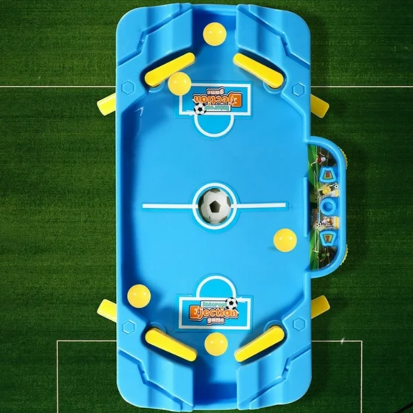 Blue and yellow toy foosball table on a green surface