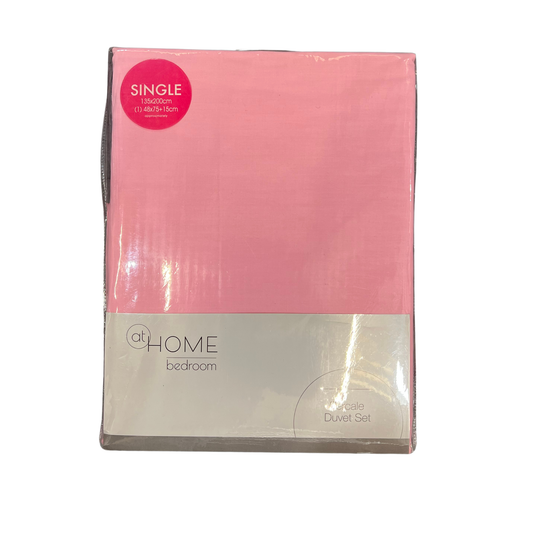 Pink duvet cover set in packaging with 'at HOME bedroom' branding on a white background