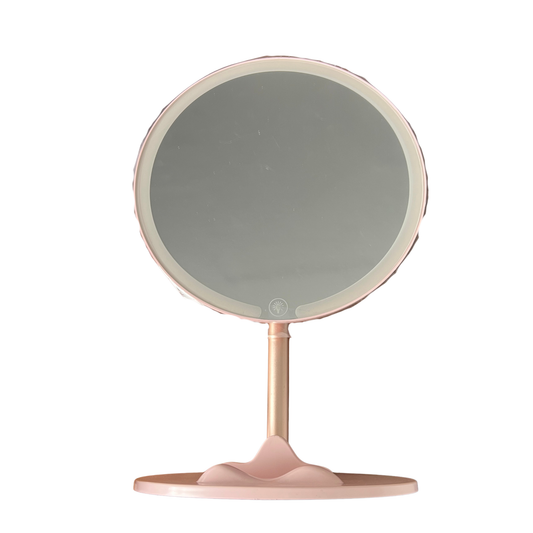 Round makeup mirror with a pink base on a white background